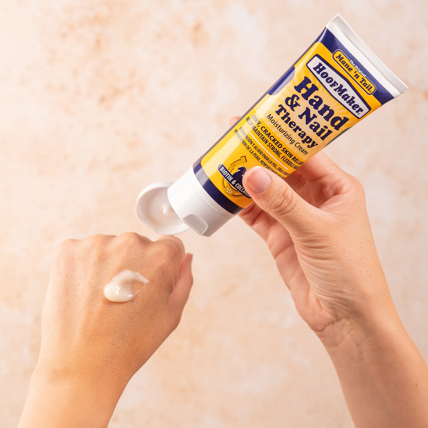 A person putting on 3.4 ounce Mane 'n Tail Hoofmaker on the back of their left hand. In front of a beige background