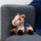 Small Mocha horse stuffed animal wearing a royal blue branded mane 'n tail saddle. Standing on a couch