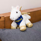 Small Pegasus horse stuffed animal wearing a royal blue branded mane 'n tail bandana. Standing on a cushion