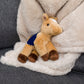 Small Prancer Horse horse stuffed animal wearing a royal blue branded mane 'n tail saddle. Standing on a blanket